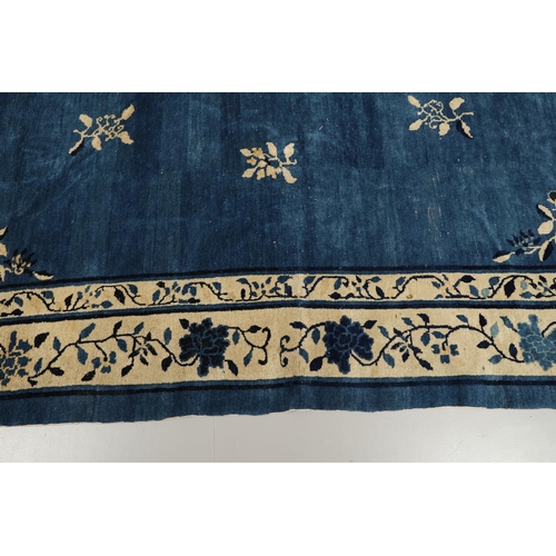 1322 - A 19TH CENTURY CHINESE CARPET. the indigo field with a central roundel framed by sprigs and spandrel... 