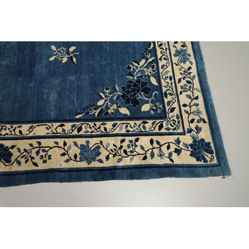 1322 - A 19TH CENTURY CHINESE CARPET. the indigo field with a central roundel framed by sprigs and spandrel... 