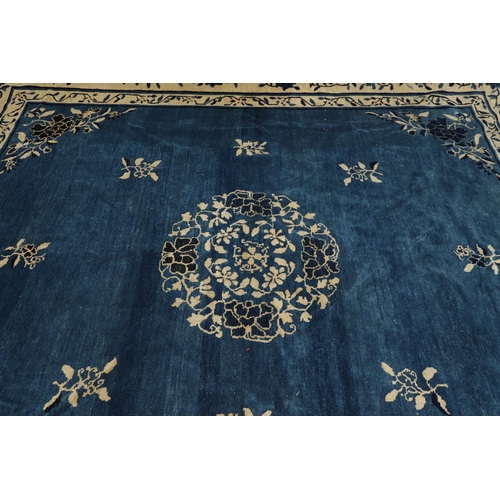 1322 - A 19TH CENTURY CHINESE CARPET. the indigo field with a central roundel framed by sprigs and spandrel... 