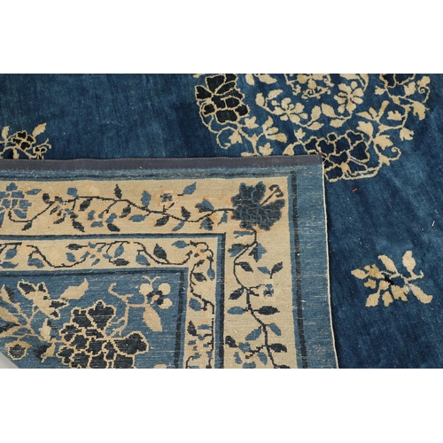 1322 - A 19TH CENTURY CHINESE CARPET. the indigo field with a central roundel framed by sprigs and spandrel... 