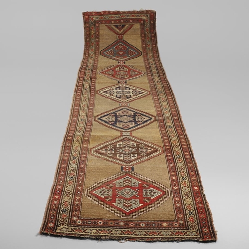 1324 - A NORTH WEST PERSIAN RUNNER, CIRCA 1900. the camel ground with a column of stepped diamond medallion... 