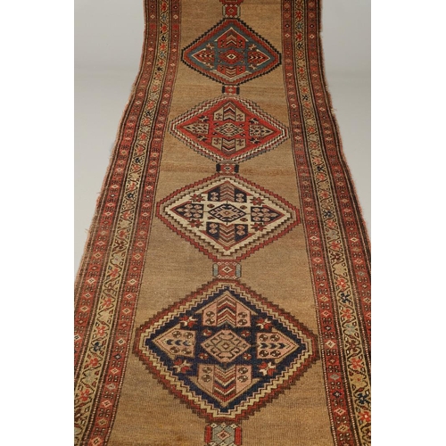 1324 - A NORTH WEST PERSIAN RUNNER, CIRCA 1900. the camel ground with a column of stepped diamond medallion... 