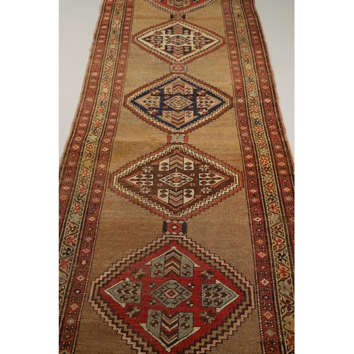 1324 - A NORTH WEST PERSIAN RUNNER, CIRCA 1900. the camel ground with a column of stepped diamond medallion... 