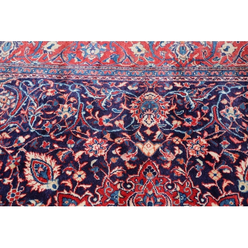 1325 - A PERSIAN SAROUKH CARPET, CIRCA 1970. the deep indigo field of scrolling vines and flowers centred b... 