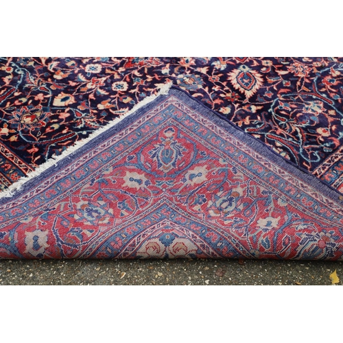 1325 - A PERSIAN SAROUKH CARPET, CIRCA 1970. the deep indigo field of scrolling vines and flowers centred b... 