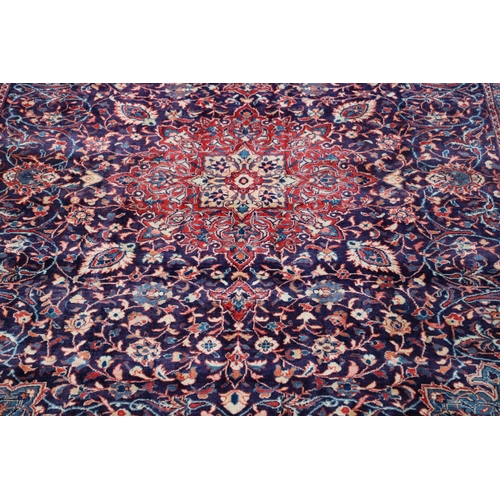 1325 - A PERSIAN SAROUKH CARPET, CIRCA 1970. the deep indigo field of scrolling vines and flowers centred b... 