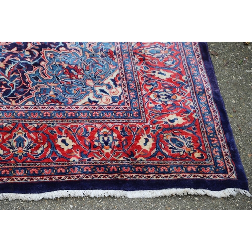 1325 - A PERSIAN SAROUKH CARPET, CIRCA 1970. the deep indigo field of scrolling vines and flowers centred b... 