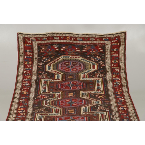 1327 - AN EAST CAUCASIAN RUG, CIRCA 1900. the charcoal field with central panel containing a column of hook... 