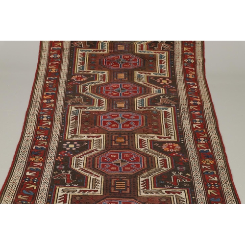 1327 - AN EAST CAUCASIAN RUG, CIRCA 1900. the charcoal field with central panel containing a column of hook... 