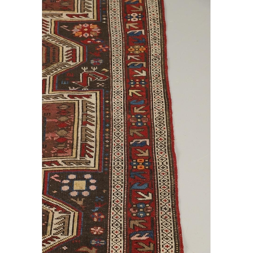 1327 - AN EAST CAUCASIAN RUG, CIRCA 1900. the charcoal field with central panel containing a column of hook... 