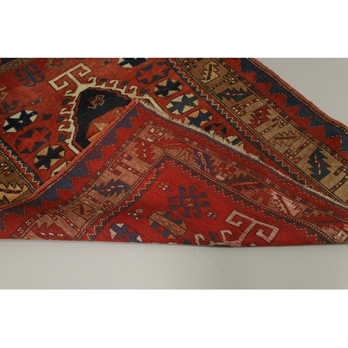 1329 - A KAZAK RUG, CENTRAL CAUCASUS, CIRCA 1910. the madder field with two panels containing geometric mot... 