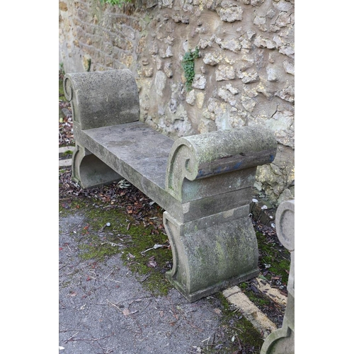 1333 - A PAIR OF CARVED STONE GARDEN BENCHES. with scroll end supports to a rectangular seat, upon arched p... 