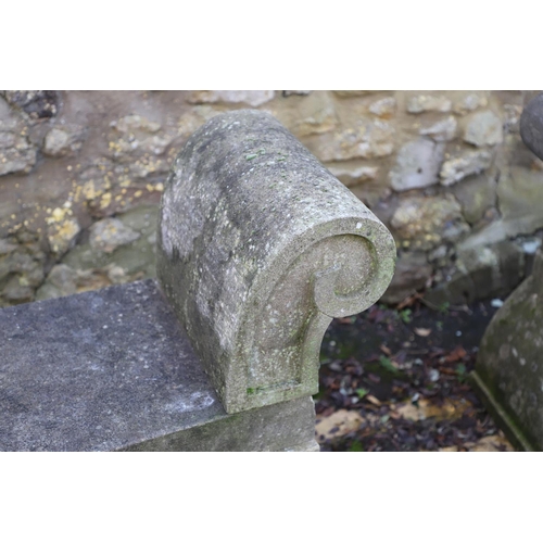 1333 - A PAIR OF CARVED STONE GARDEN BENCHES. with scroll end supports to a rectangular seat, upon arched p... 