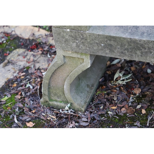 1333 - A PAIR OF CARVED STONE GARDEN BENCHES. with scroll end supports to a rectangular seat, upon arched p... 