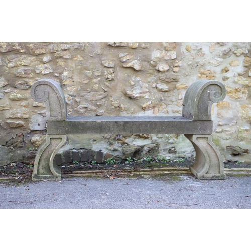 1333 - A PAIR OF CARVED STONE GARDEN BENCHES. with scroll end supports to a rectangular seat, upon arched p... 