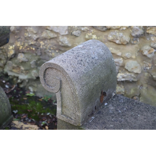 1333 - A PAIR OF CARVED STONE GARDEN BENCHES. with scroll end supports to a rectangular seat, upon arched p... 