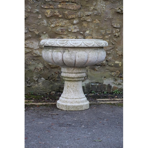 1337 - A PAIR OF LARGE CARVED GRANITE URNS. of circular lobed form, on turned column bases, height 52cm, wi... 