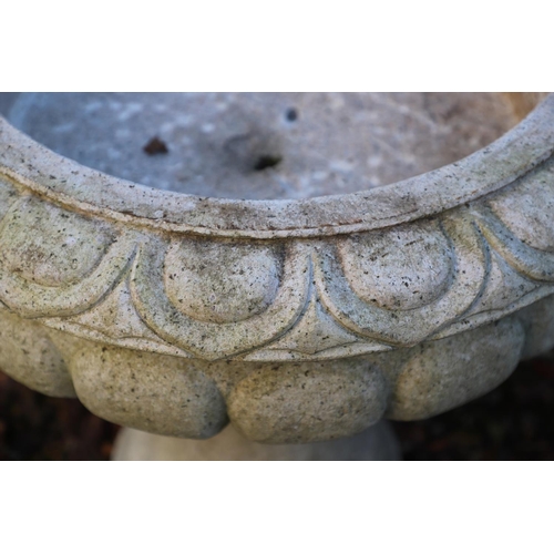 1337 - A PAIR OF LARGE CARVED GRANITE URNS. of circular lobed form, on turned column bases, height 52cm, wi... 