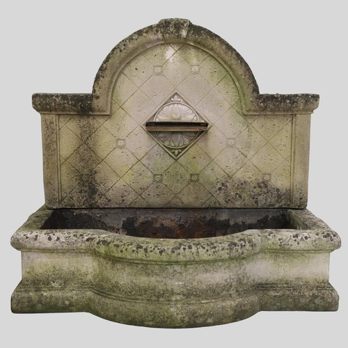 1339 - A LARGE RECONSTITUTED STONE WALL FOUNTAIN. the arched back with floral rosettes above a basin of sha... 