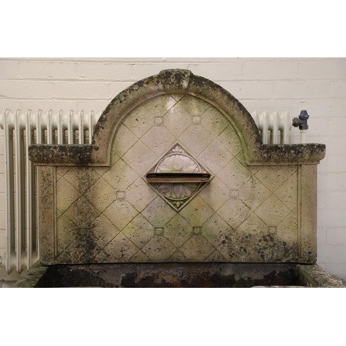 1339 - A LARGE RECONSTITUTED STONE WALL FOUNTAIN. the arched back with floral rosettes above a basin of sha... 