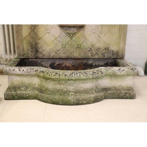 1339 - A LARGE RECONSTITUTED STONE WALL FOUNTAIN. the arched back with floral rosettes above a basin of sha... 