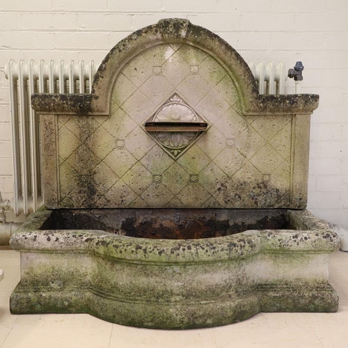 1339 - A LARGE RECONSTITUTED STONE WALL FOUNTAIN. the arched back with floral rosettes above a basin of sha... 