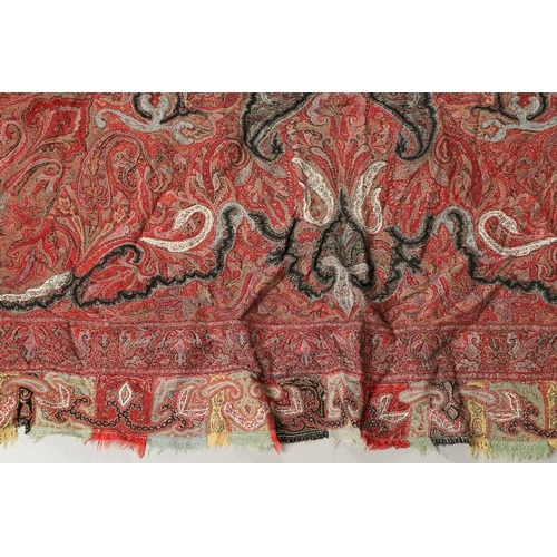 523 - ANTIQUE PAISLEY SHAWL. Probably late 19thc, a square shaped woollen shawl, in typical colours with b... 