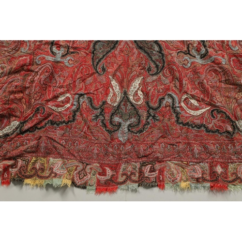 523 - ANTIQUE PAISLEY SHAWL. Probably late 19thc, a square shaped woollen shawl, in typical colours with b... 