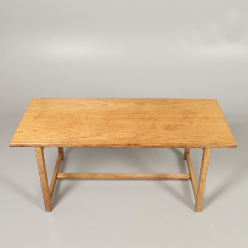 584 - COTSWOLD SCHOOL WALNUT COFFEE TABLE. The walnut table with a rectangular shaped top, supported on le... 