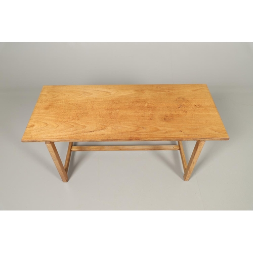 584 - COTSWOLD SCHOOL WALNUT COFFEE TABLE. The walnut table with a rectangular shaped top, supported on le... 