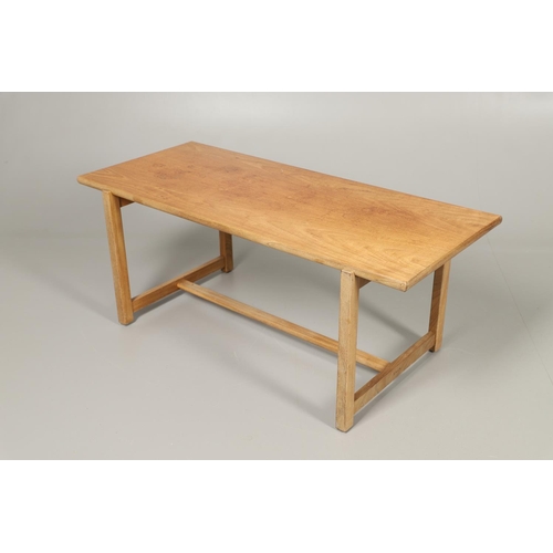 584 - COTSWOLD SCHOOL WALNUT COFFEE TABLE. The walnut table with a rectangular shaped top, supported on le... 