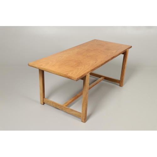 584 - COTSWOLD SCHOOL WALNUT COFFEE TABLE. The walnut table with a rectangular shaped top, supported on le... 