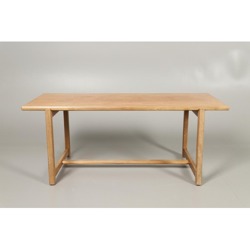 584 - COTSWOLD SCHOOL WALNUT COFFEE TABLE. The walnut table with a rectangular shaped top, supported on le... 