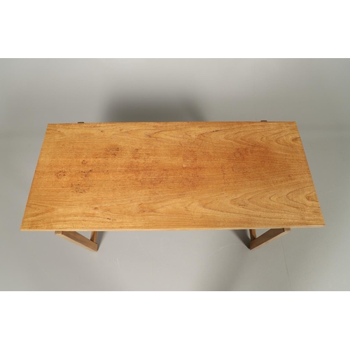 584 - COTSWOLD SCHOOL WALNUT COFFEE TABLE. The walnut table with a rectangular shaped top, supported on le... 