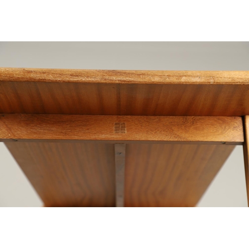 584 - COTSWOLD SCHOOL WALNUT COFFEE TABLE. The walnut table with a rectangular shaped top, supported on le... 