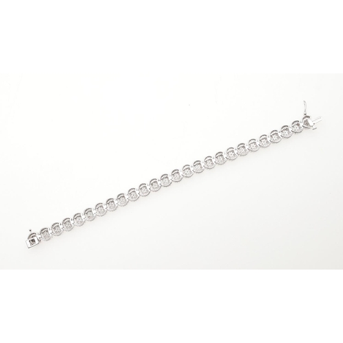 1015 - A DIAMOND BRACELET. formed with overlapping diamond clusters, in white gold, the diamonds weigh 5.00... 