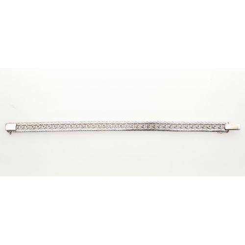 1020 - A DIAMOND AND GOLD LINE BRACELET. set with a row of circular-cut diamonds within a gold border, with... 