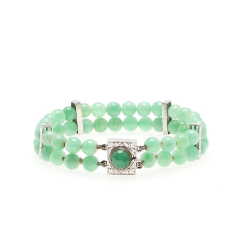 1023 - A JADE AND GOLD BRACELET. formed as two rows of jade beads, with 9ct white gold engraved spacers, wi... 