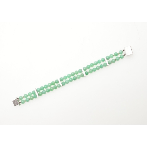 1023 - A JADE AND GOLD BRACELET. formed as two rows of jade beads, with 9ct white gold engraved spacers, wi... 