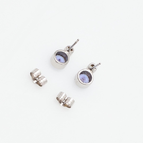 1027 - A PAIR OF TANZANITE AND DIAMOND EARRINGS. each earring set with a collet set circular-cut tanzanite ... 