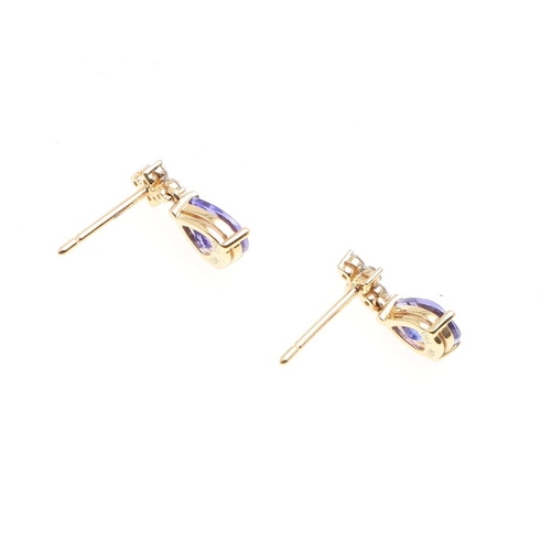 1029 - A PAIR OF TANZANITE AND DIAMOND DROP EARRINGS. each earring mounted with a pear-shaped tanzanite dro... 