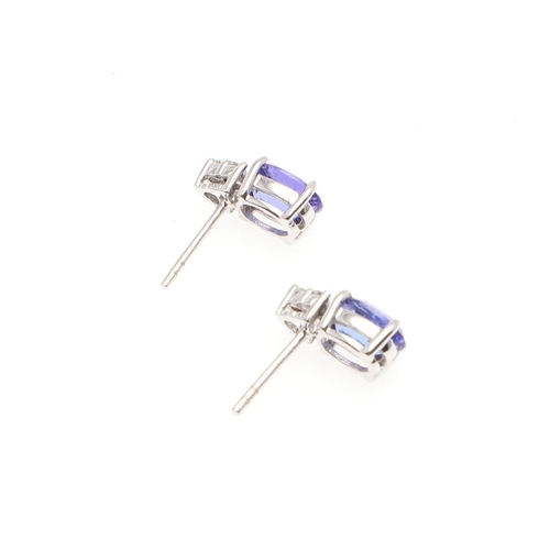 1030 - A PAIR OF TANZANITE AND DIAMOND STUD EARRINGS. each earring mounted with an oval-shaped tanzanite an... 