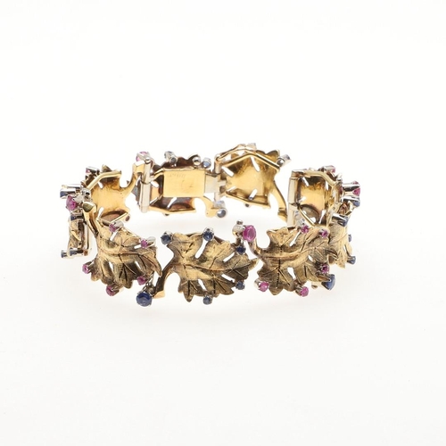 1041 - AN 18CT GOLD, RUBY AND SAPPHIRE BRACELET BY BIRKS OF CANADA. of maple leaf design, mounted with circ... 