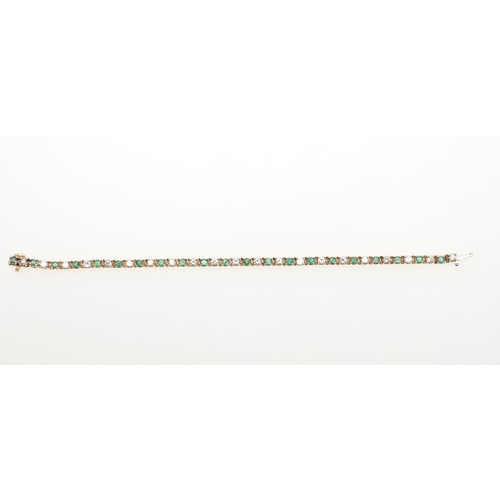 1045 - AN EMERALD AND DIAMOND BRACELET. mounted alternately with circular-cut emeralds and diamonds, in 14c... 