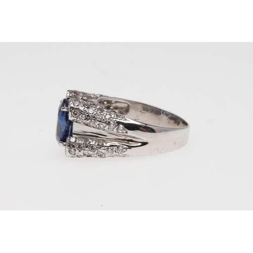 1074 - A SAPPHIRE AND DIAMOND RING. the oval-shaped sapphire is set with two circular-cut diamonds to each ... 