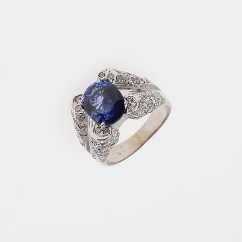 1074 - A SAPPHIRE AND DIAMOND RING. the oval-shaped sapphire is set with two circular-cut diamonds to each ... 