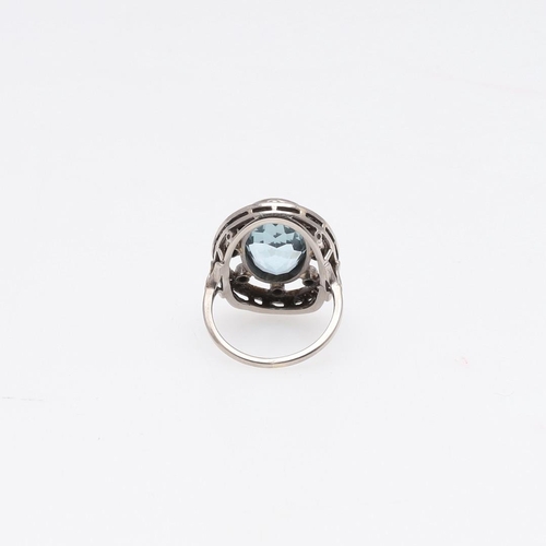 1077 - AN AQUAMARINE AND DIAMOND RING. the oval-shaped aquamarine is set within an openwork surround of cir... 