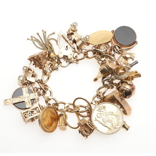 799 - A 9CT GOLD CURB LINK CHARM BRACELET. with padlock clasp and suspending many assorted 9ct gold charms... 