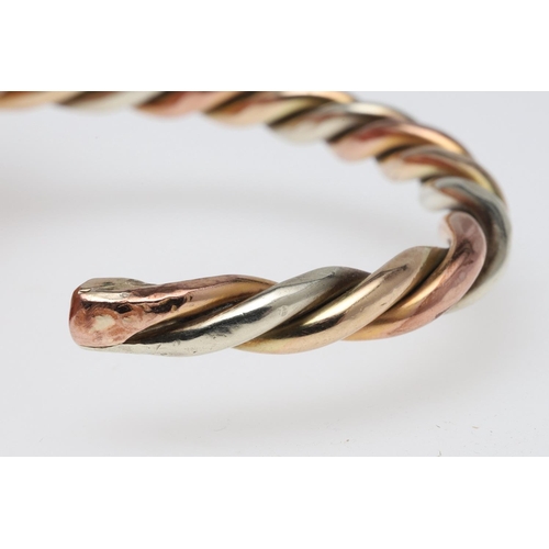 800 - A THREE COLOUR GOLD BANGLE. of twist form, internal measurement 6.0cm across, 37.4 grams.