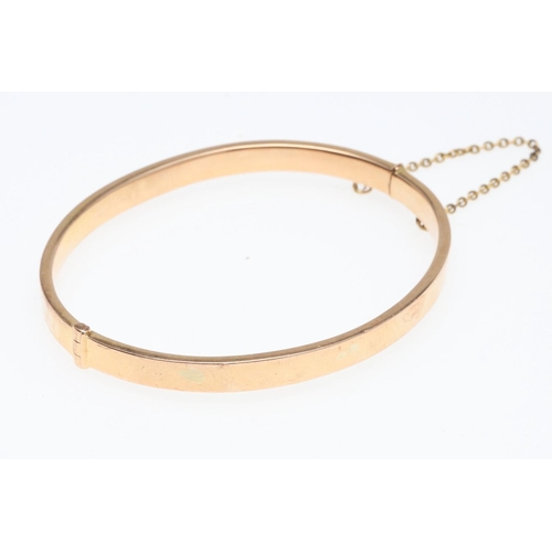 802 - A 15CT GOLD HALF HINGED BANGLE. of oval shape and plain form, internal measurements 5 x 6.2cm., 8.3 ... 